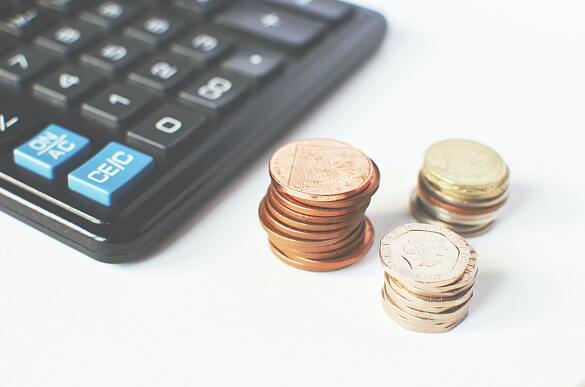 Bild eines Taschenrechners mit Münzen 
˜ Bildnachweis: Foto von Breakingpic von Pexels